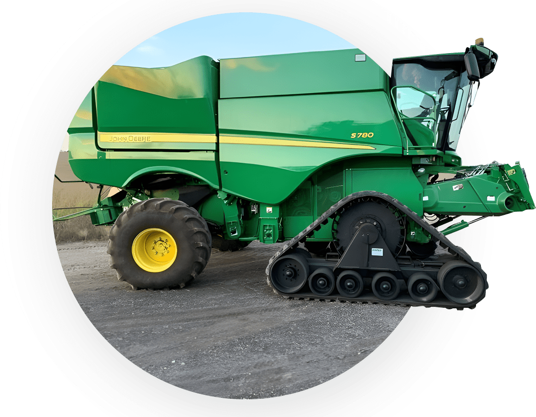 A green tractor with yellow wheels is parked in the dirt.